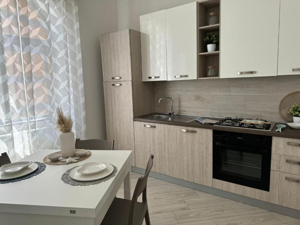 a kitchen with a white table and a white counter top at Casa Verga in Monopoli