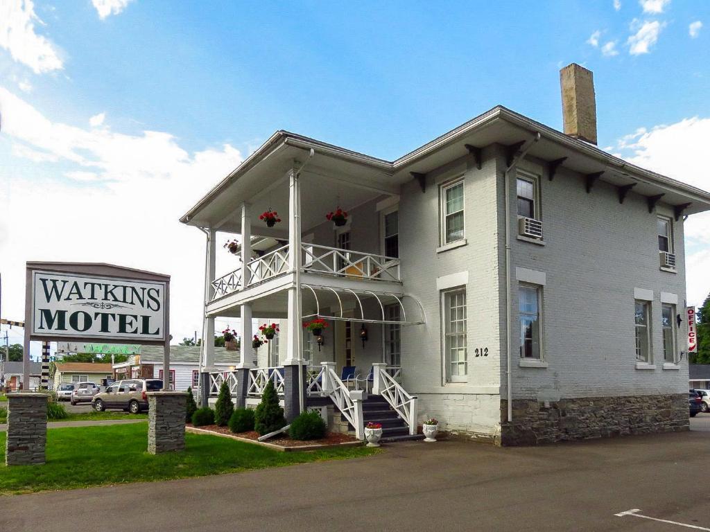 un bâtiment blanc avec un panneau devant lui dans l'établissement Watkins Motel, à Watkins Glen