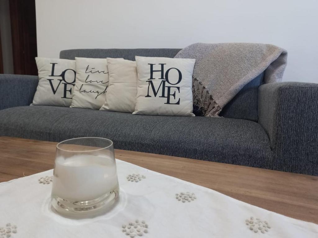 um copo de leite numa mesa em frente a um sofá em Casa Nera em Esquel