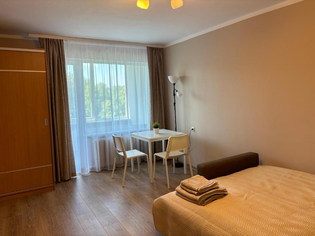 1 dormitorio con 1 cama y 1 mesa con sillas en Salaspils center apartment, en Salaspils
