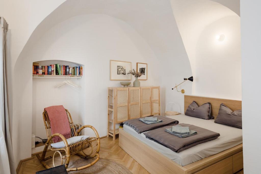 - une chambre avec un lit et une chaise dans l'établissement Marktplatz-Residenz - 110 m vom Traunsee, à Gmunden