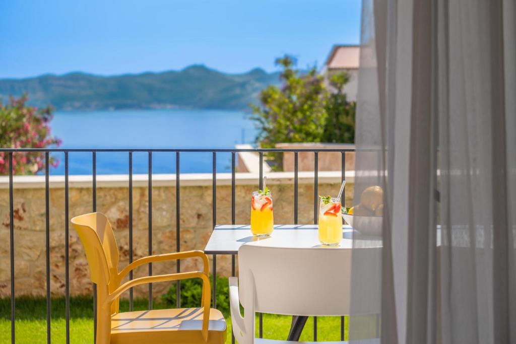 een witte tafel met 2 drankjes op een balkon bij Meri Suite Apart Kaş in Kas