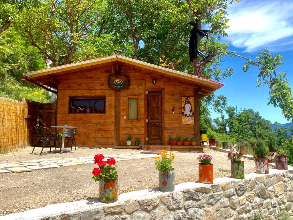 une petite cabane en bois avec des fleurs devant elle dans l'établissement RVilla, à Pávliani