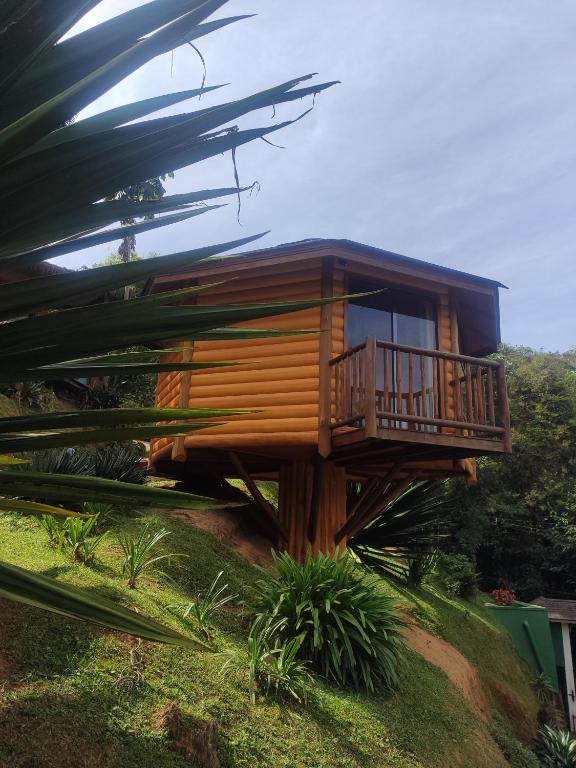 a tree house on a hill with a balcony at Pousada Mirante do Céu in Visconde De Maua
