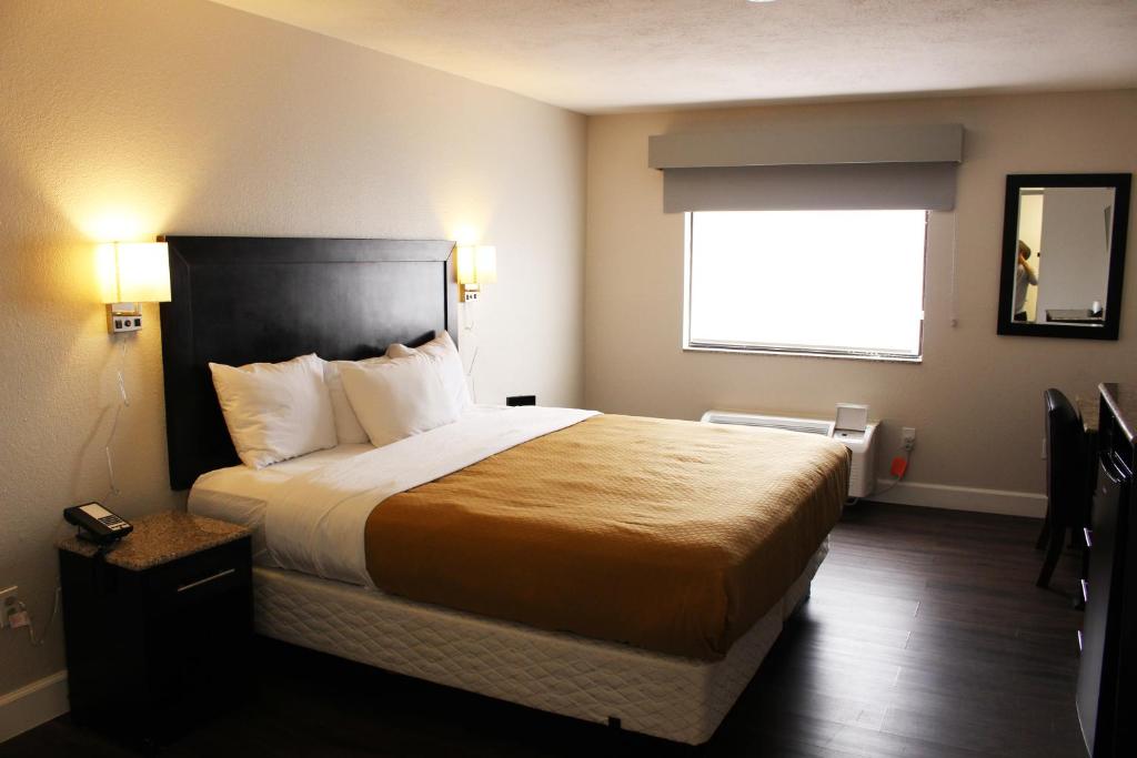 a hotel room with a bed and a window at Baymont by Wyndham Del Rio in Del Rio