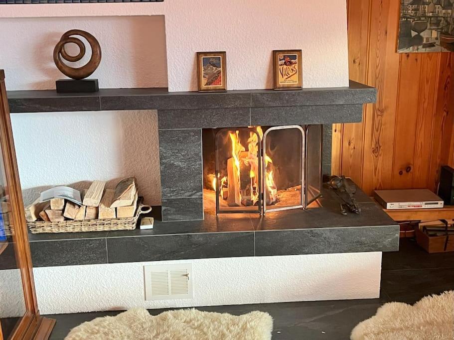 a fireplace in a living room with a fire in it at Beryl Flat for 5, stunning views in Villars-sur-Ollon