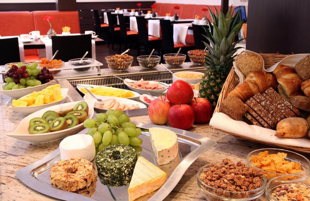 a table topped with lots of different types of food at Leonardo Hotel München City Center in Munich