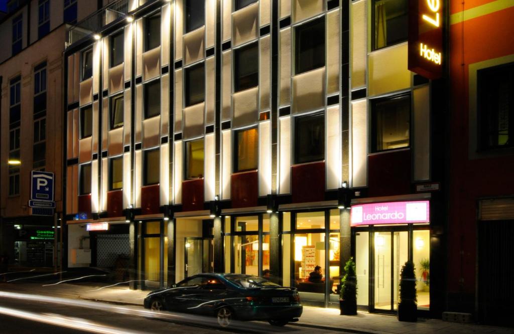 a car parked in front of a building at night at Leonardo Hotel München City Center in Munich