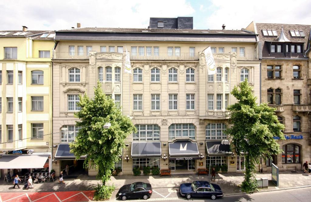 duży budynek z samochodami zaparkowanymi przed nim w obiekcie Leonardo Boutique Hotel Düsseldorf w mieście Düsseldorf