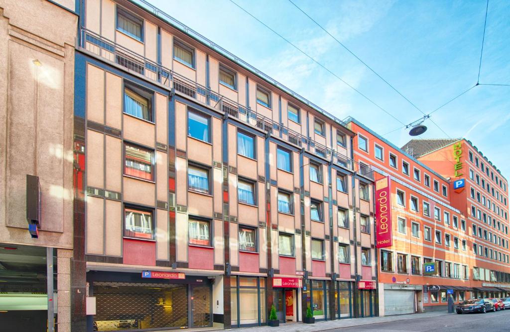 a large building on a city street with at Leonardo Hotel München City Center in Munich