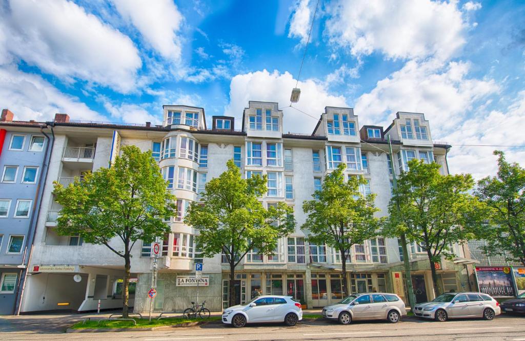ein großes Gebäude mit davor geparkt in der Unterkunft Leonardo Hotel Muenchen City West in München