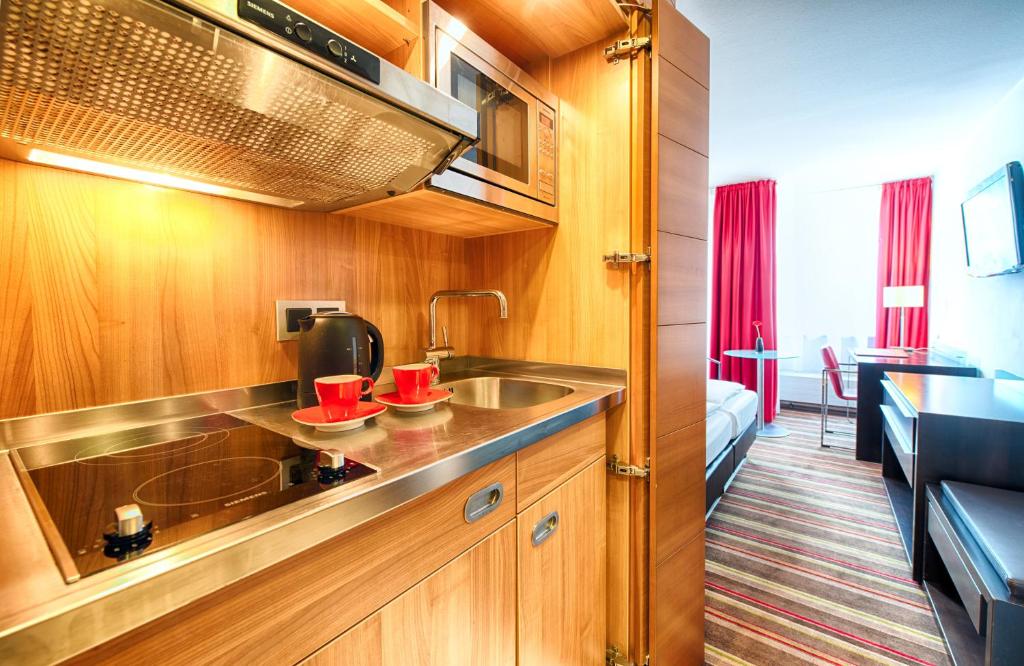 Kuchyň nebo kuchyňský kout v ubytování Leonardo Hotel Muenchen City West