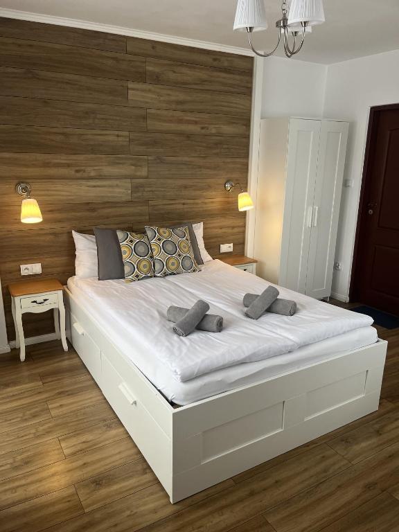 - une chambre avec un grand lit blanc et une tête de lit en bois dans l'établissement Rodzinna Ostoja, à Zakopane