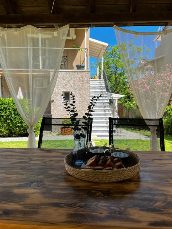 Armonia Apartments & Studios في Perivólion: طاولة مع مزهرية وصحن من الطعام