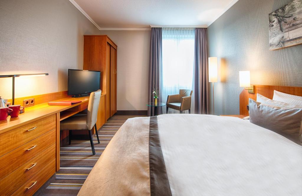 Postel nebo postele na pokoji v ubytování Leonardo Hotel Aachen