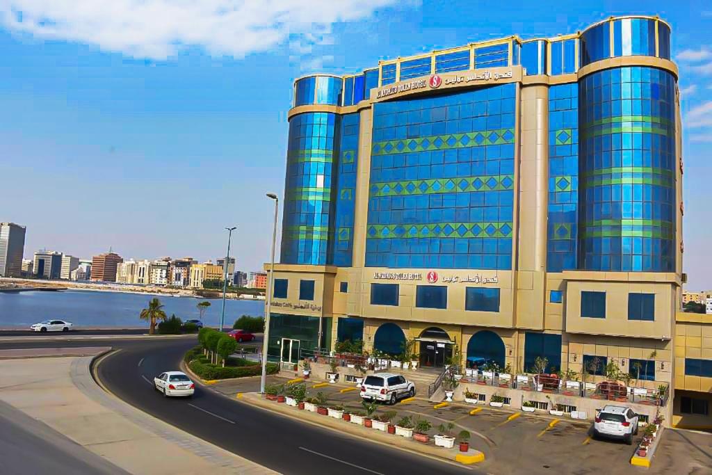 un gran edificio con coches estacionados frente a él en Al Andalus Tolen Hotel en Yeda
