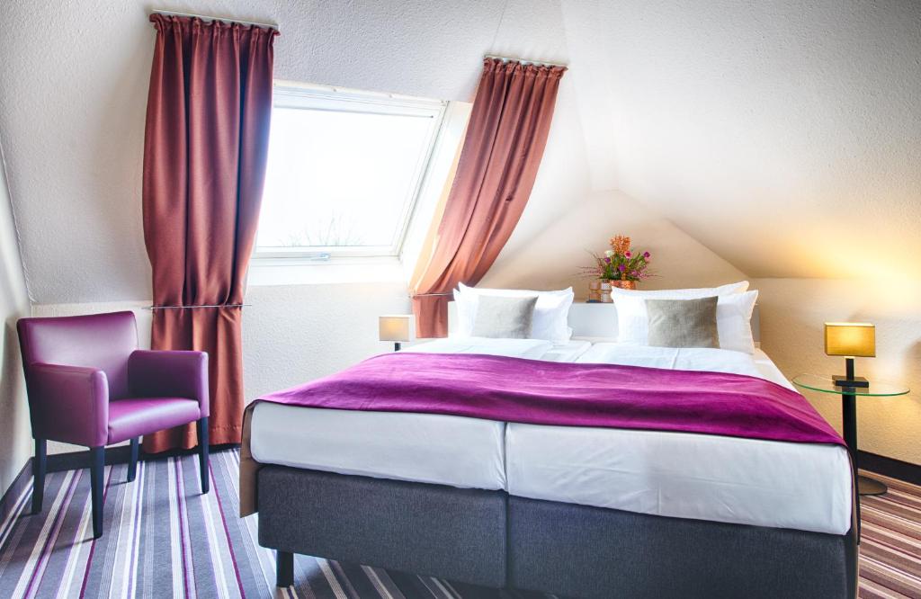 a bedroom with a large bed and a window at Leonardo Hotel Mannheim-Ladenburg in Ladenburg
