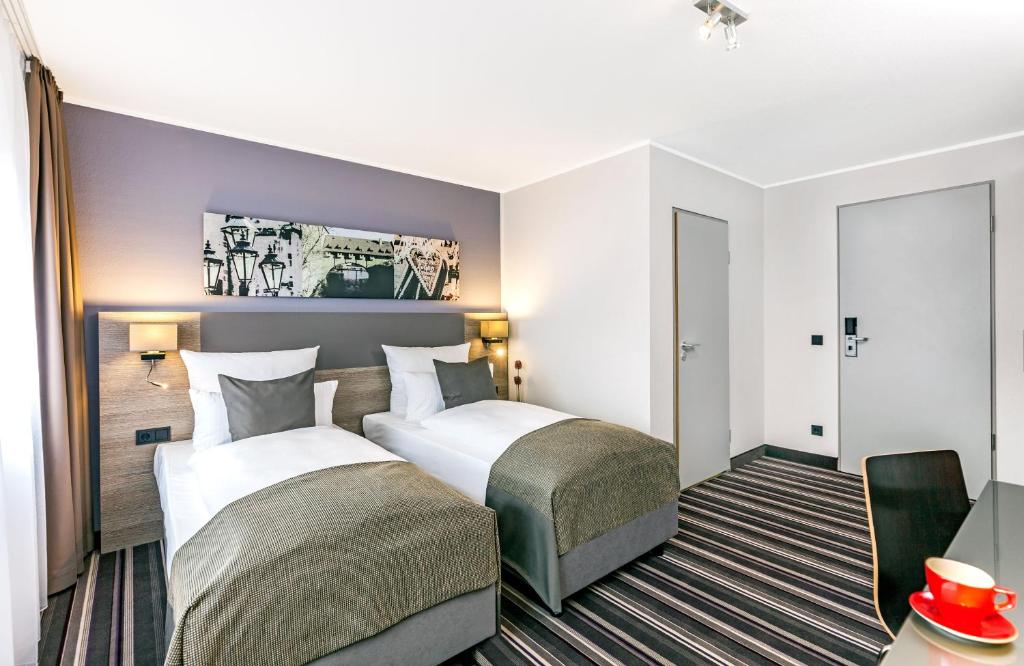 Postel nebo postele na pokoji v ubytování Leonardo Hotel Nürnberg