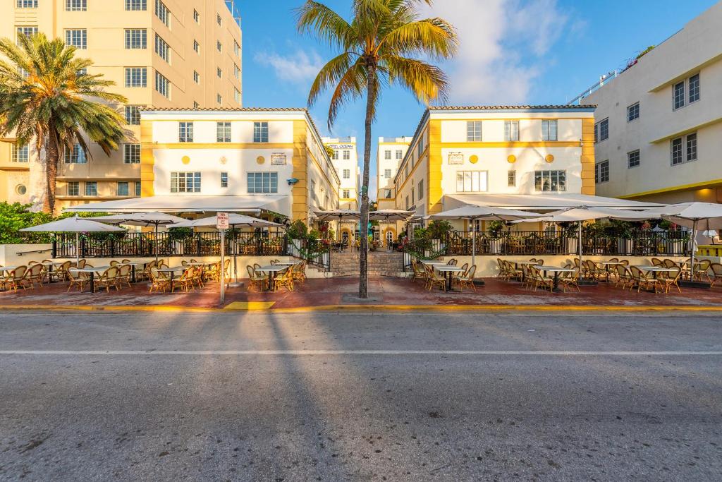 eine leere Straße mit Tischen, Sonnenschirmen und Gebäuden in der Unterkunft Hotel Ocean in Miami Beach