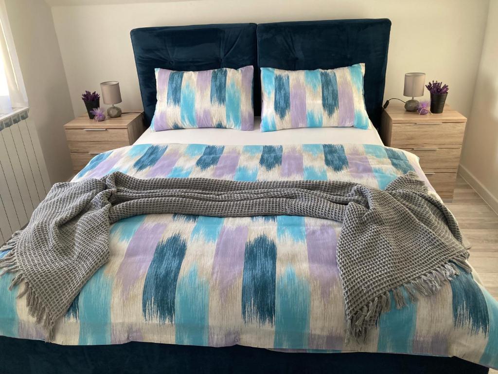 łóżko z kolorową kołdrą i poduszkami w obiekcie Sobe VaLux Valpovo w mieście Valpovo