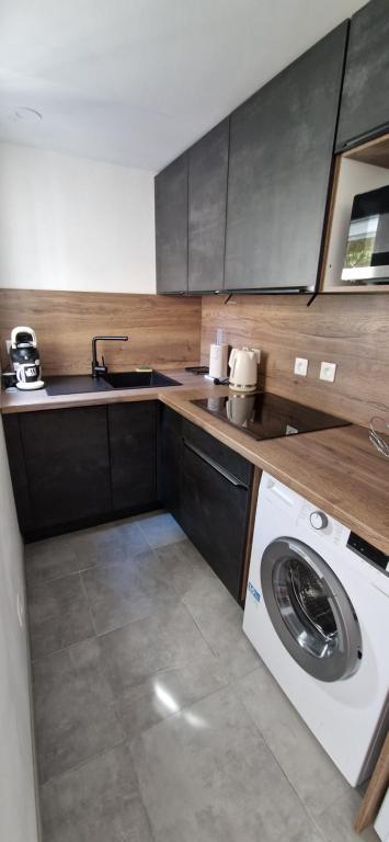 une cuisine avec une machine à laver et un évier dans l'établissement Studio Cap d'Agde avec piscine, tennis entièrement rénové, au Cap d'Agde