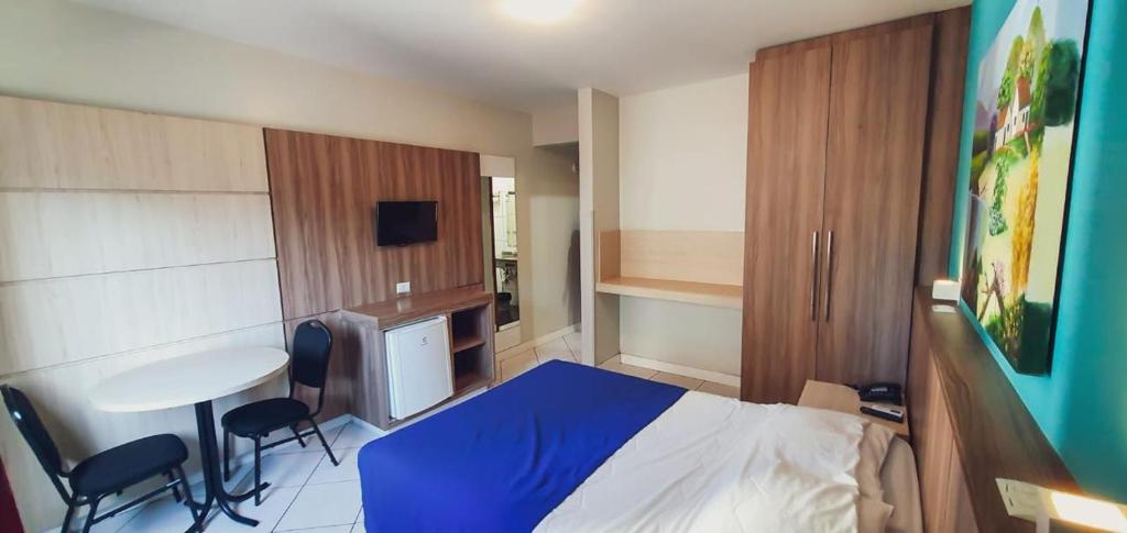 um quarto com uma cama, uma mesa e cadeiras em Hotel das Américas em Balneário Camboriú