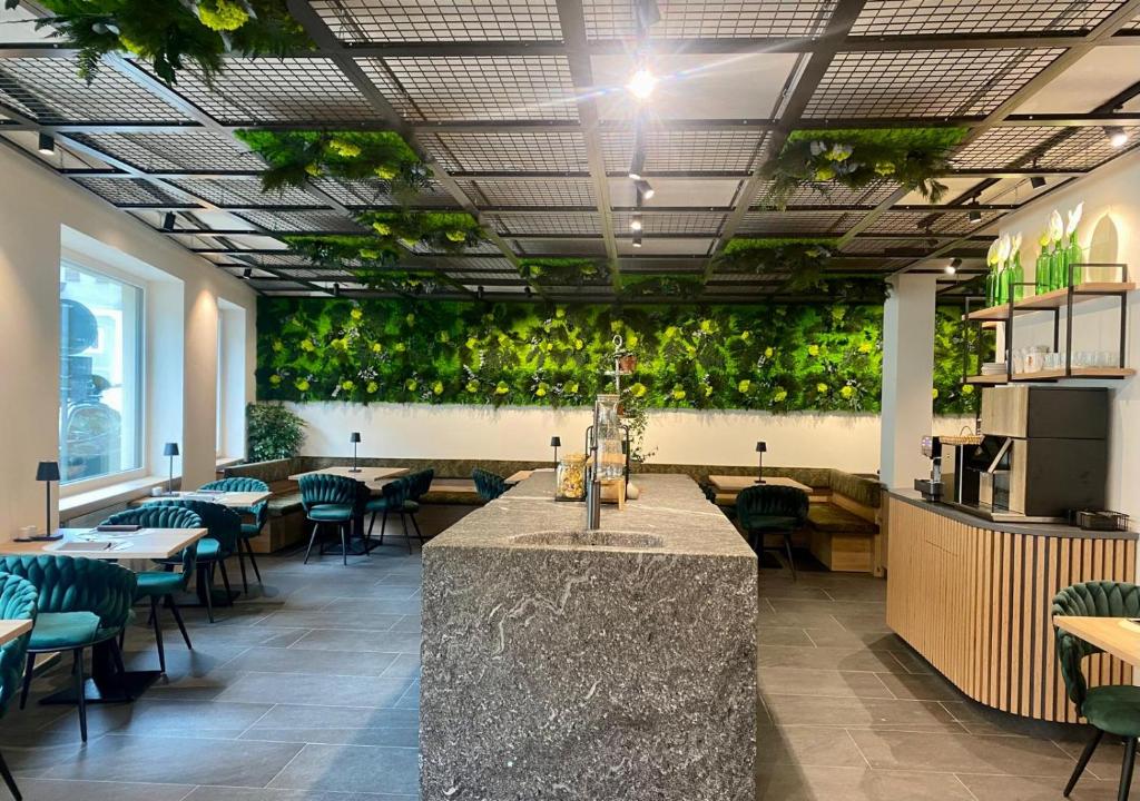 un restaurante con mesas y plantas verdes en las paredes en Sole Boutique Hotel en Vipiteno