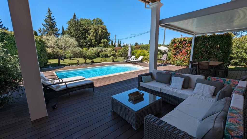 patio con sofá, sillas y piscina en Villa Cara avec piscine privée, en Carpentras