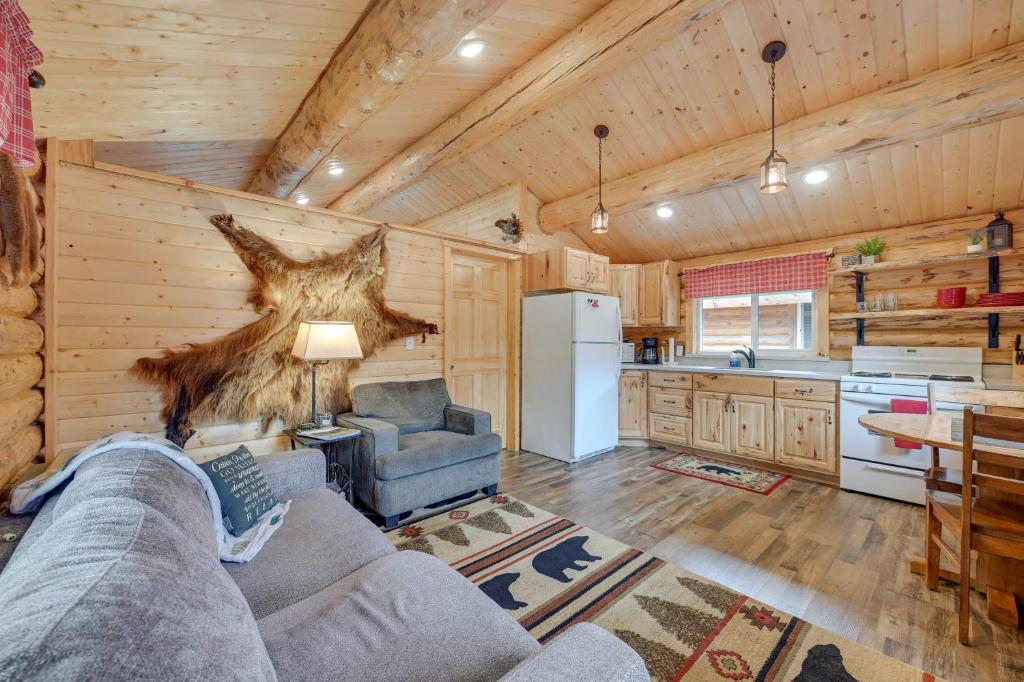 a living room with a couch and a kitchen at Charming Soldotna Cabin Near Kenai River Fishing! in Soldotna
