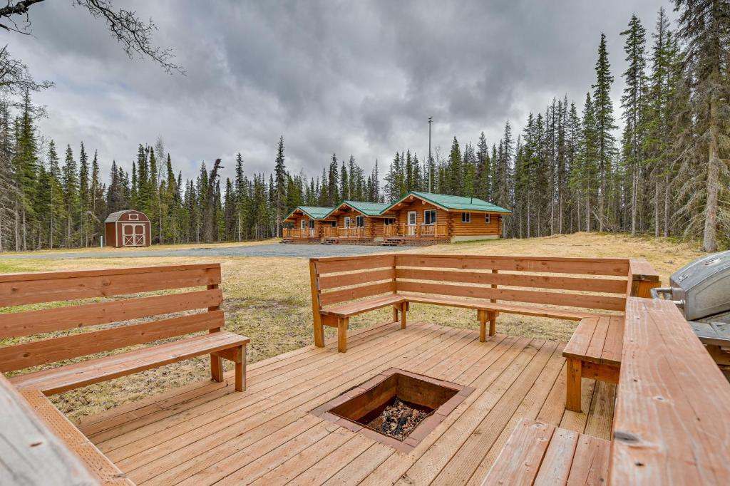 a wooden deck with two benches and a log cabin at Soldotna Fishermans Cabin about 6 Mi to Kenai River in Soldotna