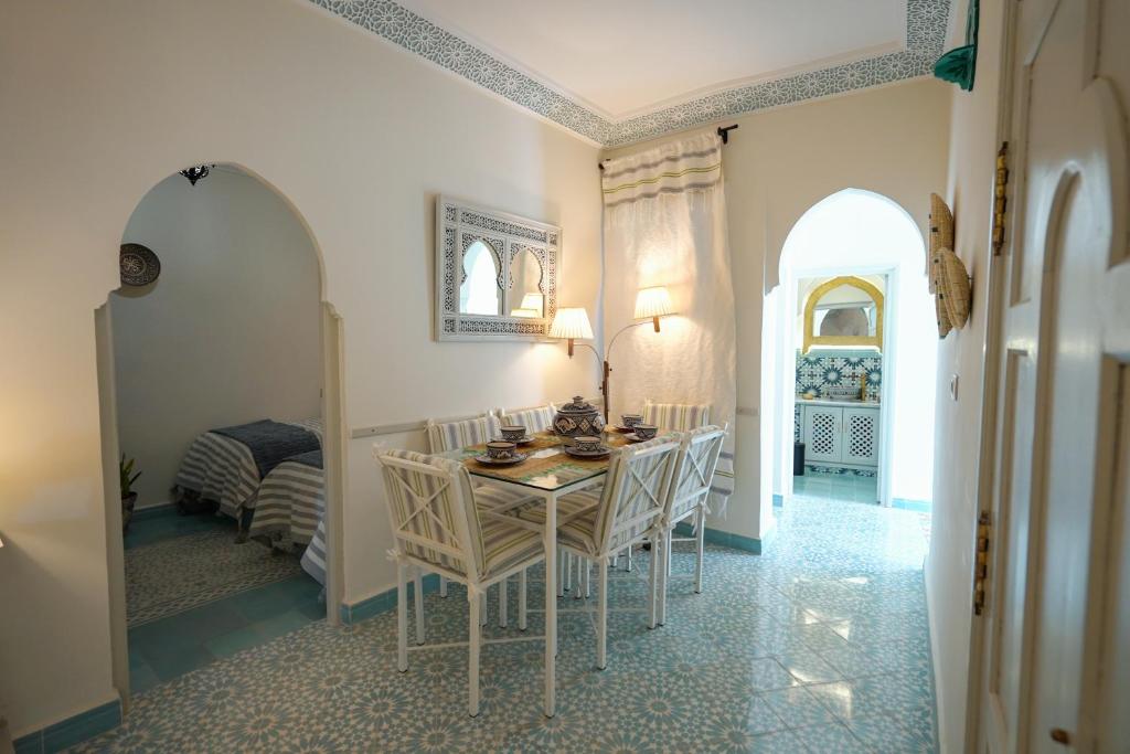 a dining room with a table and chairs and a bedroom at Dar Badr in Tangier
