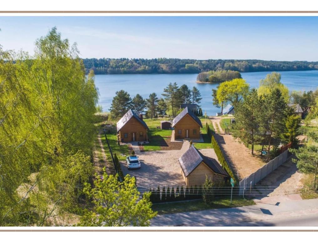 eine Luftansicht eines Hauses mit See in der Unterkunft Karmelowe Domki Kaszuby, 80m do jeziora in Stężyca