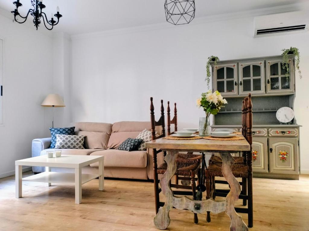 een woonkamer met een tafel en een bank bij Apartamento en el barrio marítimo del Serrallo in Tarragona