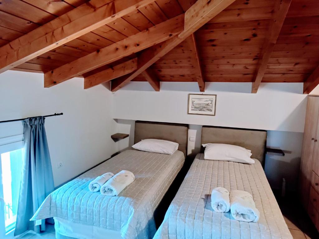 Duas camas num quarto com tectos em madeira em Hermione Port Luxury Residence em Ermioni