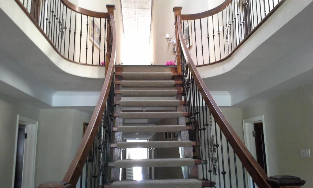 una escalera en una casa con barandillas de madera en Guest House Villa Mishkan, en Runaway Bay