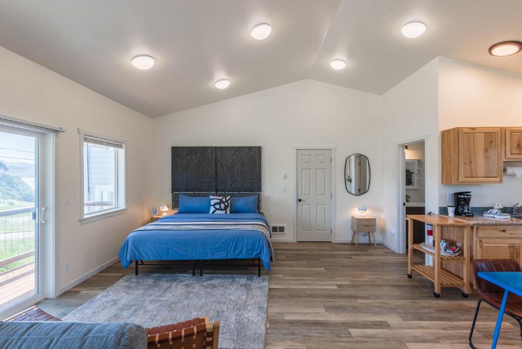 奥福德港#StayinMyDistrict Oceanview Studio Loft的一间带蓝色床的卧室和一间厨房