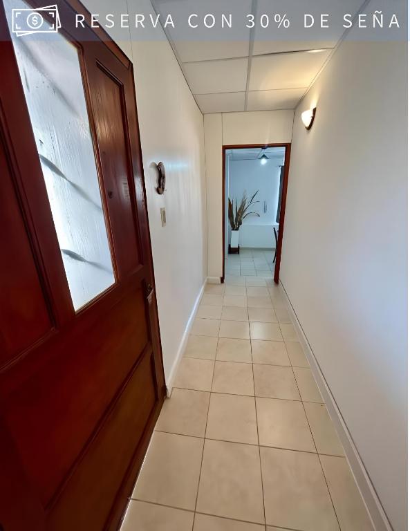 korytarz z drzwiami i podłogą wyłożoną kafelkami w obiekcie Residencia Céntrica w mieście Chilecito