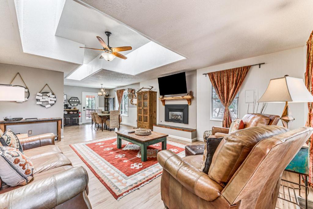 a living room with leather furniture and a fireplace at Ruidoso House with Beautiful Indoor and Outdoor Space! in Ruidoso