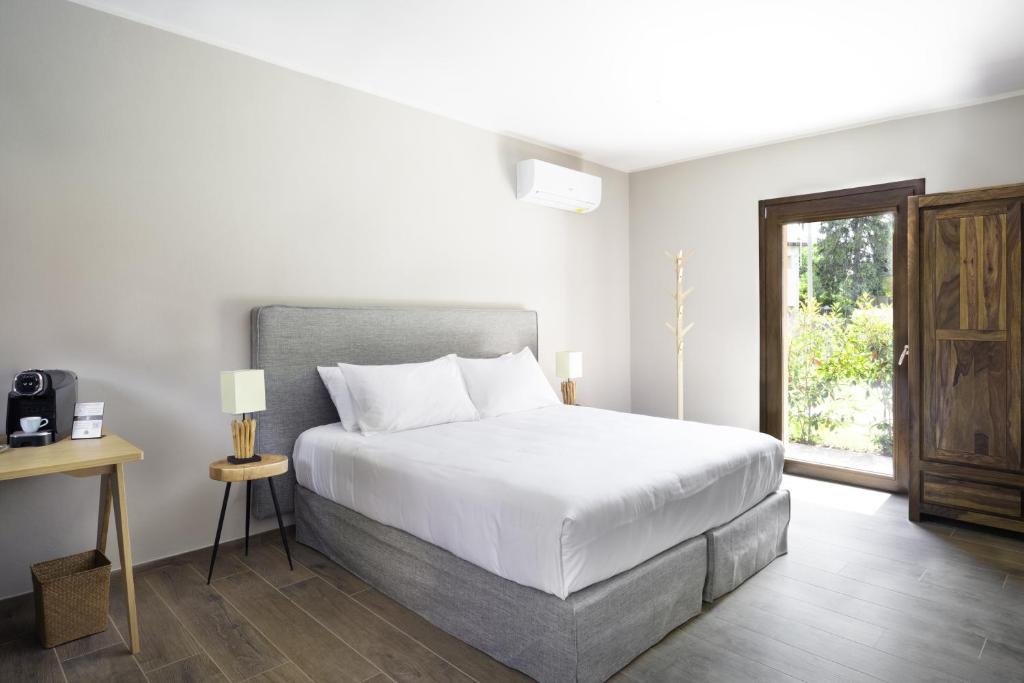 a white bedroom with a bed and a window at Villa Il Platano in Como
