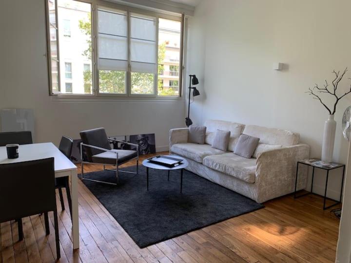 un salon avec un canapé et une table dans l'établissement Appartement Tour Eiffel Invalides, à Paris