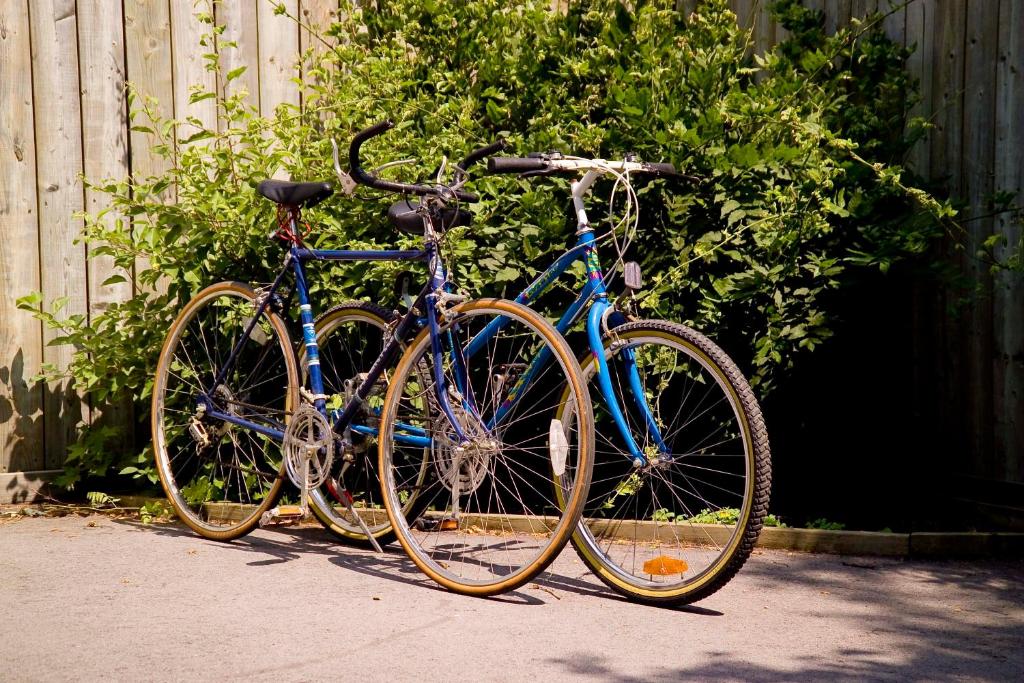 duas bicicletas estacionadas uma ao lado da outra ao lado de uma cerca em WeatherPine Inn em Niagara on the Lake