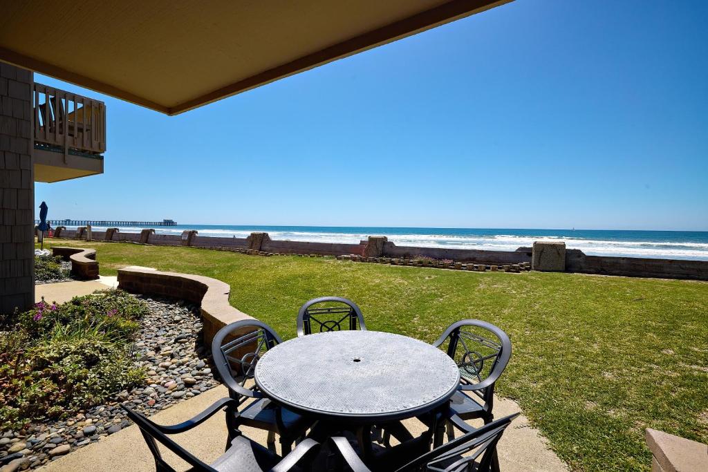een tafel en stoelen met het strand op de achtergrond bij D27 - Beachside Bungalow in Oceanside
