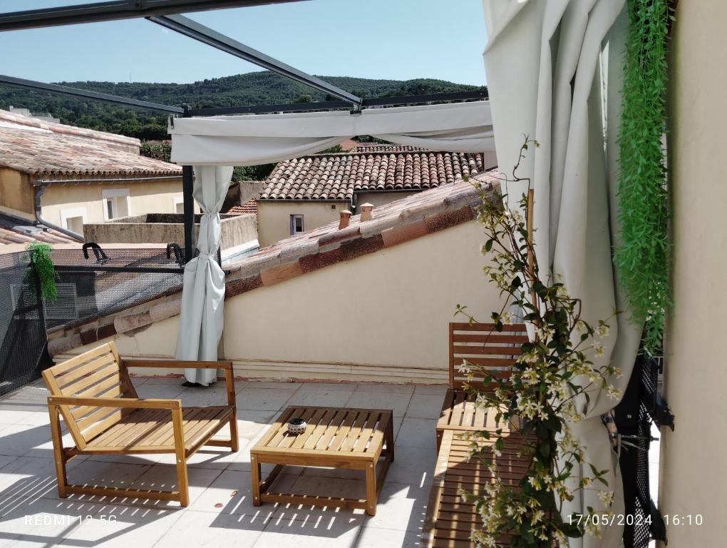 eine Terrasse mit 2 Stühlen und einem Tisch auf dem Balkon in der Unterkunft Un nid sur les toits avec terrasse in Apt