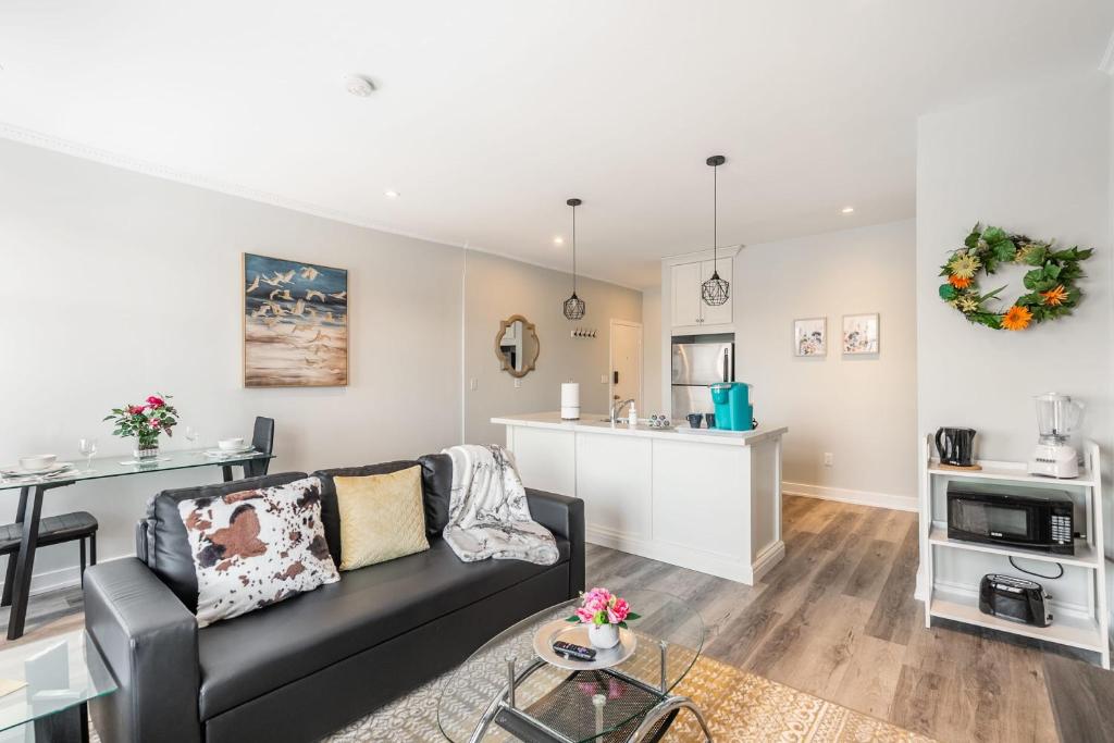 a living room with a couch and a kitchen at Cozy Condo on James Street North in Hamilton