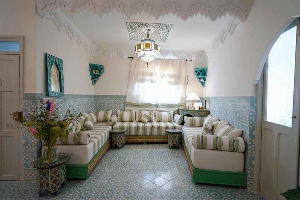 a living room with two couches and a window at Dar Badr in Tangier