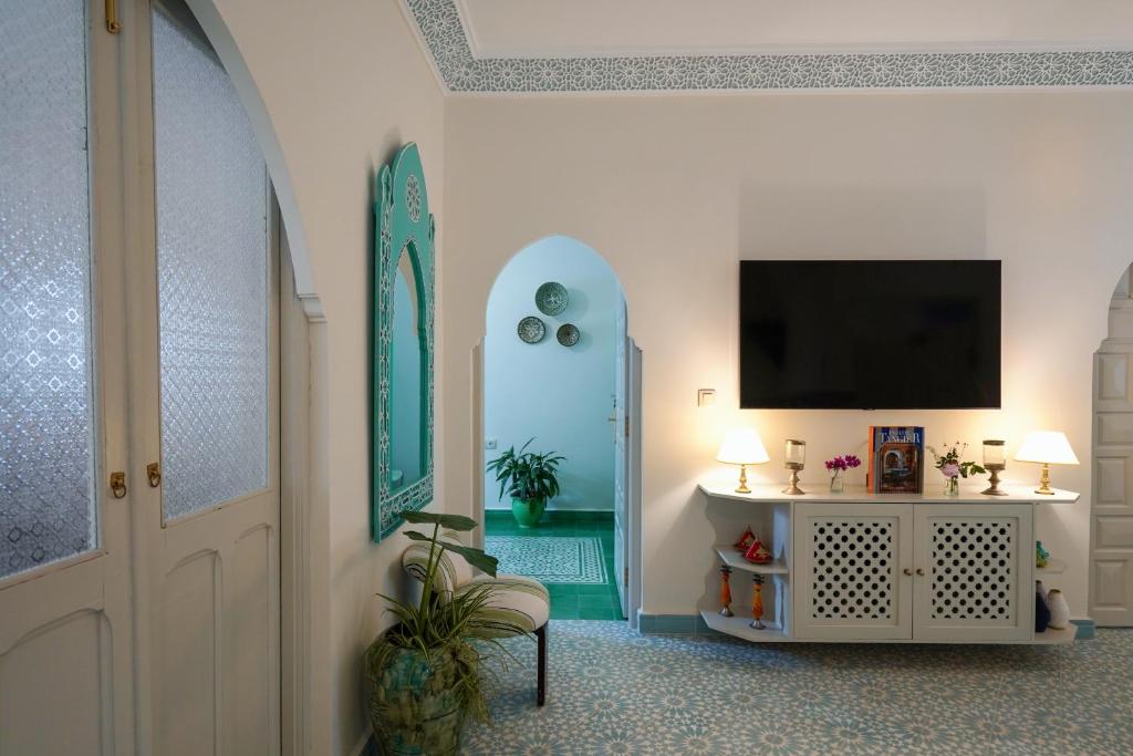a living room with a tv on a wall at Dar Badr in Tangier
