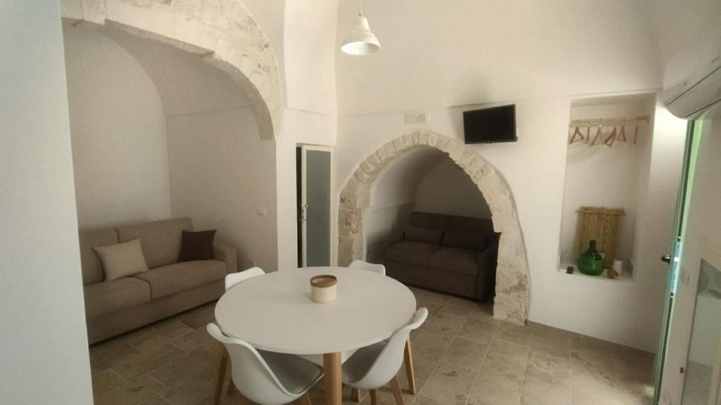 sala de estar con mesa blanca y sofá en Le Chianche, en Ceglie Messapica
