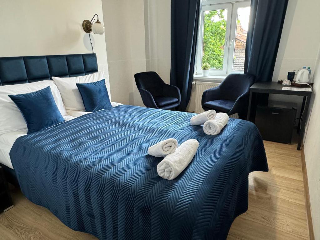 1 dormitorio con 1 cama con toallas en IRIS Aparthotel en Cracovia