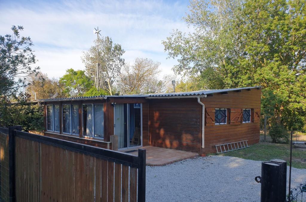 une petite cabane en bois avec une clôture et des arbres dans l'établissement cabanon en autonomie solaire 1 a 4 personnes a 900 m des plages de valras, confort simple sans équipements energivores, à Valras-Plage