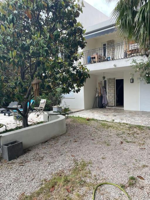une maison avec un arbre devant dans l'établissement Bas de villa avec grande piscine, à Marseille